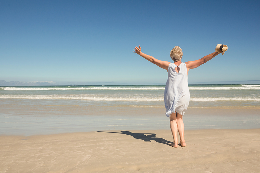 Woman standing on sand against clear sky